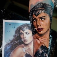 Portrait style colored forearm tattoo of seductive wounder woman