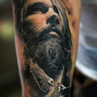 Portrait style colored forearm tattoo of man with beard face