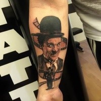 Portrait style colored forearm tattoo of cute Charlie Chaplin