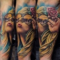 Portrait style colored forearm tattoo of woman with glasses and flower