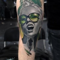 Portrait style colored forearm tattoo of woman with glasses