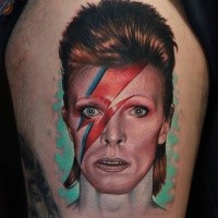 Portrait style colored interesting woman face tattoo on thigh