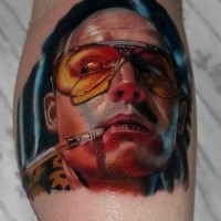 Portrait style colored leg tattoo of smoking man with glasses