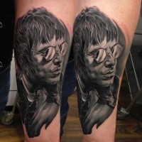 Portrait style colored leg tattoo of man face with glasses