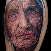 Portrait style colored leg tattoo of Mother Teresa