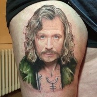 Portrait style colored man face tattoo on thigh