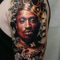 Portrait style colored shoulder tattoo of 2PAC with crown and lettering