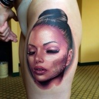 Portrait style colored thigh tattoo of woman face stylized with ornaments