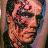 Portrait style colored thigh tattoo of Terminator face