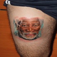 Portrait style colored thigh tattoo of famous actor face