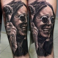 Portrait style detailed arm tattoo of famous musician with microphone