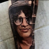 Portrait style very detailed arm tattoo of Slash face with guitar