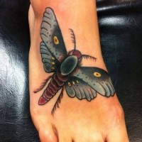 Tatuaje en el pie, polilla roja con alas verdes