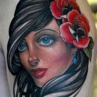Pretty young brunette portrait with red roses in hair shoulder tattoo