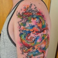 Rainbow colored Asian dragon tattoo on shoulder by Javi Wolf in watercolor style