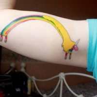 Rainbow shaped and colored funny unicorn tattoo on teenage biceps