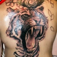 Wilder farbiger brüllender Tiger Tattoo mit Blumen am Rücken