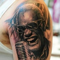 Real photo detailed black ink famous American singer tattoo on shoulder with piano keys
