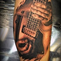 Schwarzweißer Musiker spielt   Gitarre Tattoo am Bein wie echtes Foto