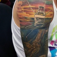 Tatuaje colorido de animal marino y barco pesquero en el hombro