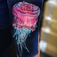 Tatuaje  de medusa brillante de colores fantásticos en el antebrazo