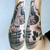 Tatuaje en el antebrazo,
bajo eléctrico impresionante con manos de guitarrista