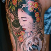 Mehrfarbiges Oberschenkel Tattoo mit Porträt der asiatischen Geisha und Blumen
