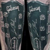 Real photo like very detailed black and white Les Paul Gibson guitar tattoo on arm