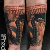Sehr detailliertes farbiges Unterarm Tattoo mit rauchender mexikanischer Frau mit Gewehr