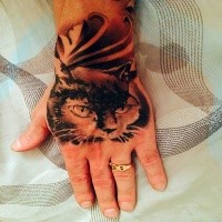 Real photo style black and white hand tattoo of mysterious cat