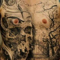 Tatuaje en el pecho y estómago, cráneo grande antiguo con cementerio con árboles secos