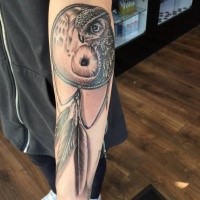 Realism style black and white forearm tattoo of dream catcher with owl