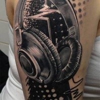 Realism style black and white shoulder tattoo of music wave with headset and lettering