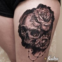 Realism style black and white thigh tattoo of human skull and rose flowers