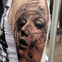 Realism style black ink shoulder tattoo of woman face