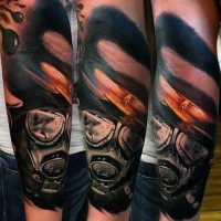 Realism style colored forearm tattoo of nuclear blast and gas mask