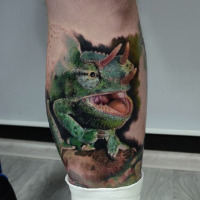 Realism style colored leg tattoo of detailed lizard