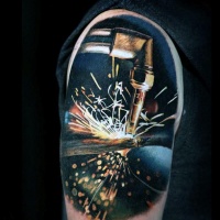 Realism style colored shoulder tattoo of welding works