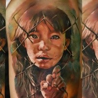 Realism style colored shoulder tattoo of small girl behind the fence