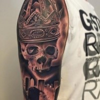 Realism style colored shoulder tattoo of human skull part with big beautiful crown and cemetery