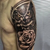 Realism style cool looking shoulder tattoo of big owl with rose flower