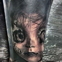 Realism style very detailed arm tattoo of creepy doll face