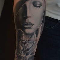 Realism style very detailed forearm tattoo of woman face with musician
