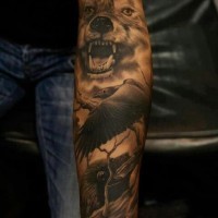 Tatuaje en el antebrazo, lobo amenazante con cuervo siniestro