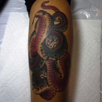 Realistic coiled snake tattoo on leg