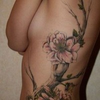 Realistic detailed branch of cherry blossoms tattoo on ribs