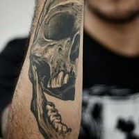 Realistisches Tattoo von halbem Totenkopf am Unterarm