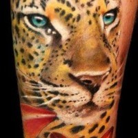 Tatuaje en el antebrazo, leopardo con ojos azules y lirio