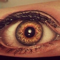 Tatuaje en el brazo de un ojo humano real.