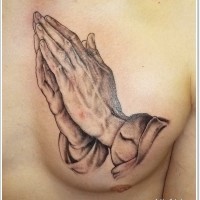 Realistic looking 3D like black and white praying hands tattoo on chest